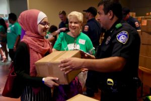 Police officers and firefighters from Hurst, Euless, and Bedford team up to help distribute school supply kits for local students during Operation Back 2 School